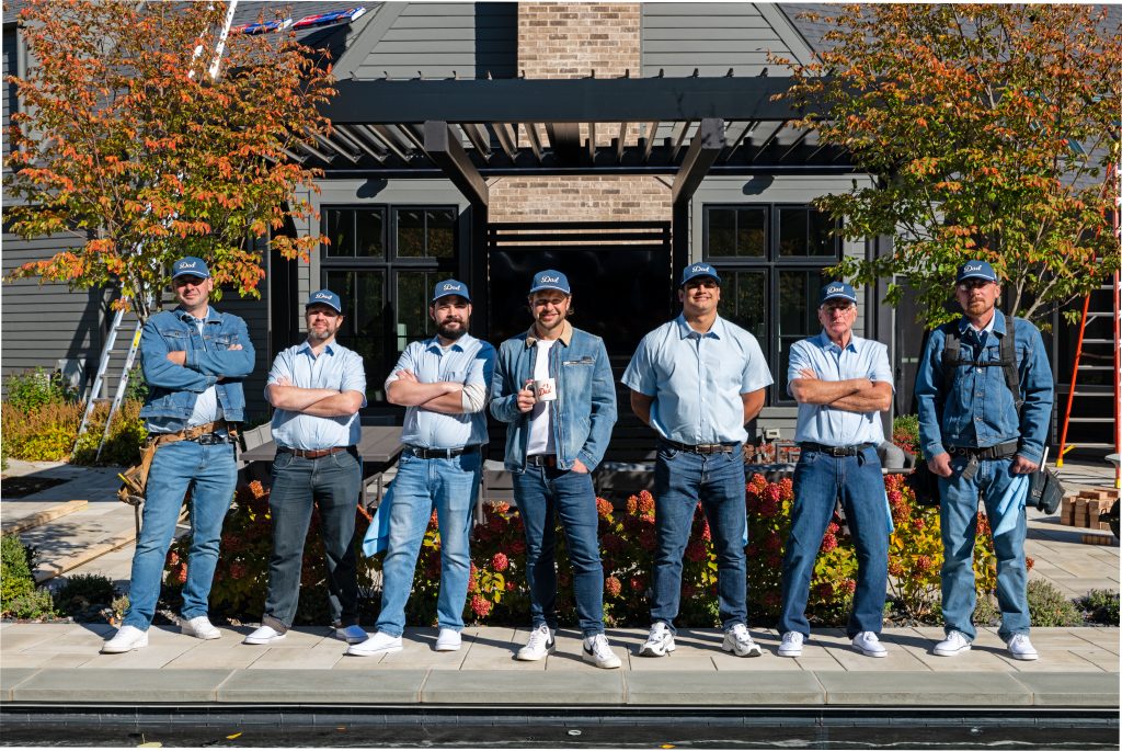 Dad Exteriors crew standing together in front of a Chicago home, representing our team of roofing, masonry, and deck specialists.