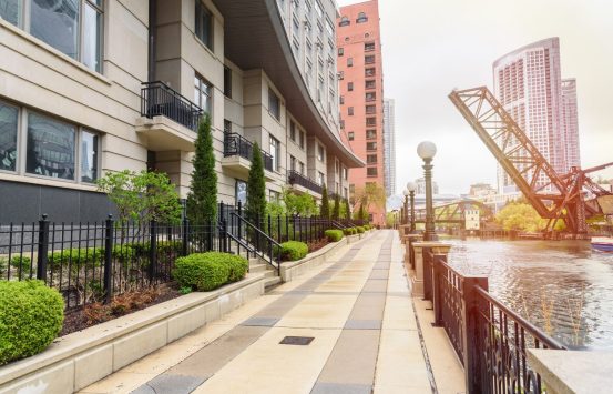 Modern apartment buildings along a deserted riverside path